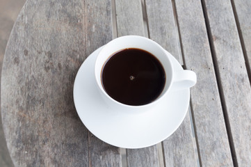 white cup of coffee on wooden table, soft focus