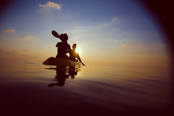 Fototapeta na wymiar silhouette of people kayaking at sunset