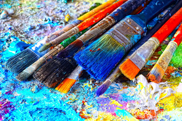 Paints and brushes,lying on painted background