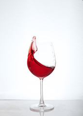 Red wine in a glass on a white background. The concept of alcohol and party.