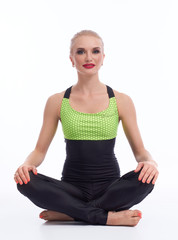 Gorgeous young woman practicing yoga sitting on the floor 