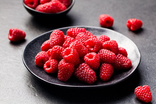 Fresh raspberries on a black bowl Slate background