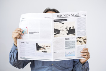 Man hand holding reading newspaper on gray background