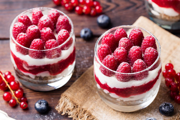 Raspberry dessert, cheesecake, trifle, mouse in a glass on a wooden background