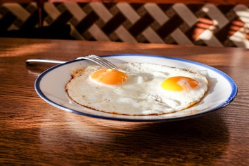 Two fried eggs on the tray with the light blue platter