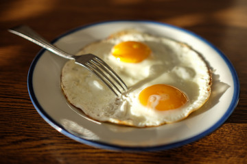 Two fried eggs on the tray with the light blue platter