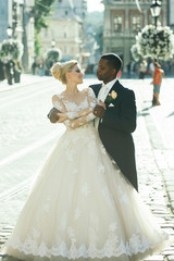 Handsome african groom hugging cute bride