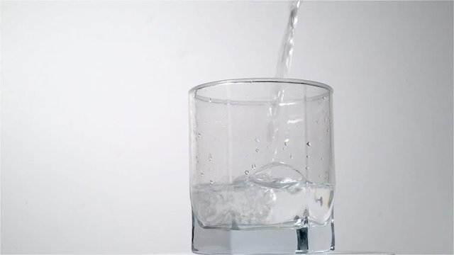 A stream of water fills a glass