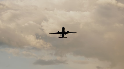 Passenger airplane taking off at sunset against the background of a very beautiful clouds