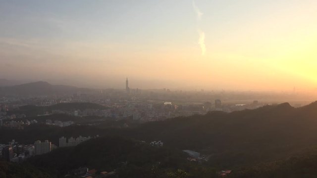 Skyline at sunset of Taipei with Taipei 101. The building was officially classified as the world's tallest in 2004, and remained such until the completion of Burj Khalifa in Dubai in 2009. Pan, 4K.