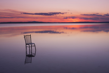 chair on a lake at sunset