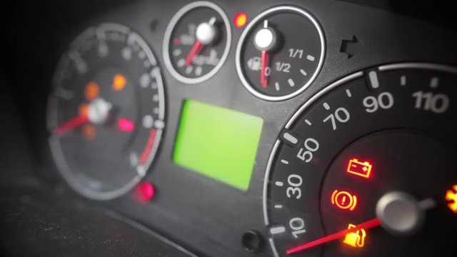 Close up footage of a car's dashboard with the battery icon lit.