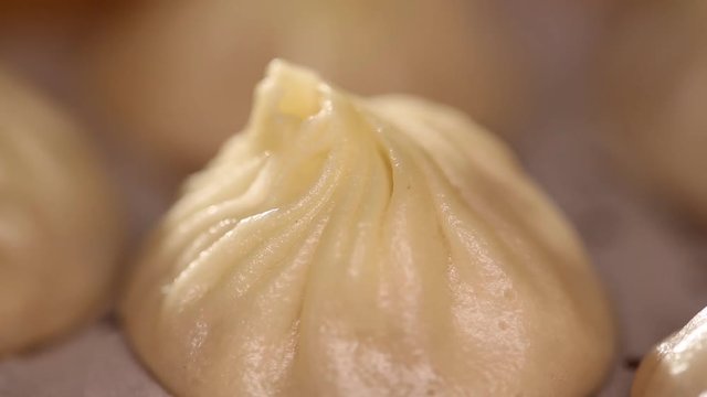 Close up of dumplings spinning in a bamboo steamer basket. The chinese dumpling generally consists of minced meat and finely chopped vegetables wrapped into a piece of dough skin.