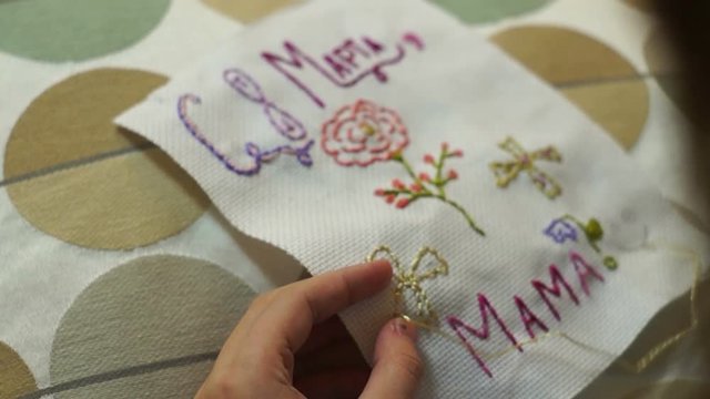 Teen girl embroiders a gift for her mother for women,s holiday