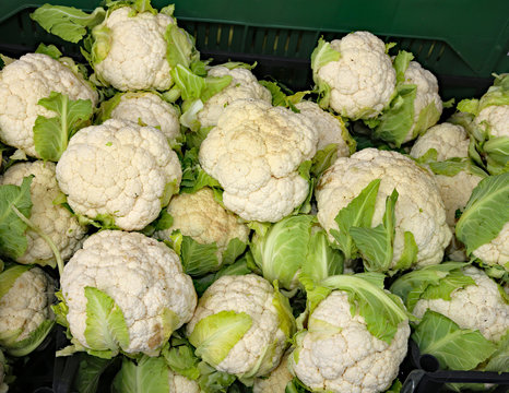 many white cauliflowers for sale in greengrocers stall