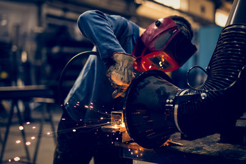 Fototapeta na wymiar Welding steel with sparks using mig mag welder 