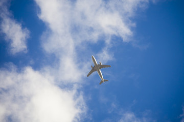 Fototapeta na wymiar airplane in the blue sky with clouds