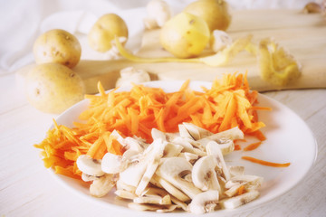 ingredients for soup, carrots and mushrooms on plate