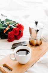 A cup of coffee, coffee on the wooden Boards, a bouquet of red roses on a white background