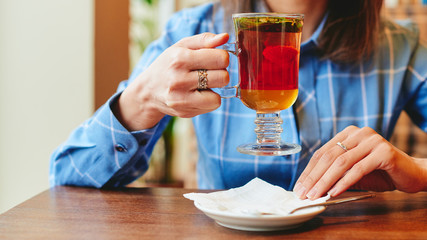 Woman drinking cocktail tea in cafe restaurant