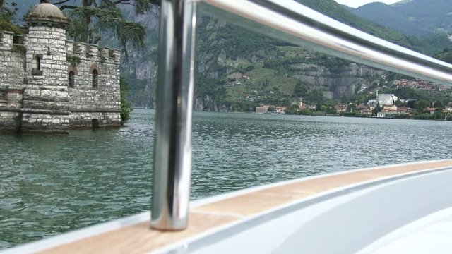 Small town on Como lake seen from a boat, with view of building on an island.