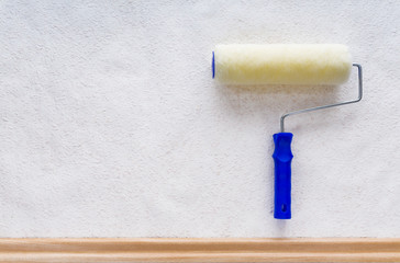 Farbrolle auf Wand mit Rauhfasertapete und Fußleiste, Hintergrund