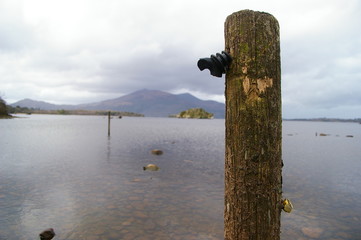 Wooden pole in front of the lake and mountain in Ireland