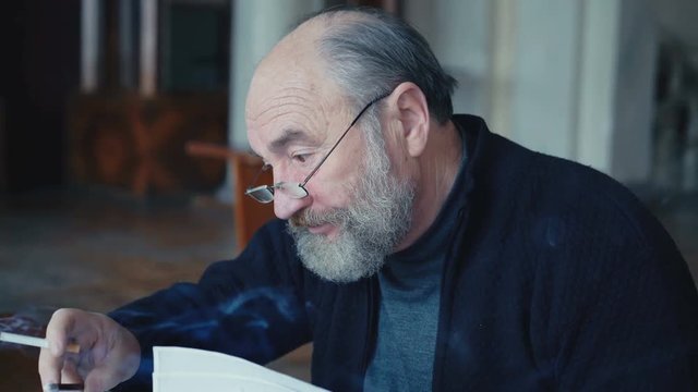 Emotional tired old man smoking cigarette, sighing and working with papers in 4K