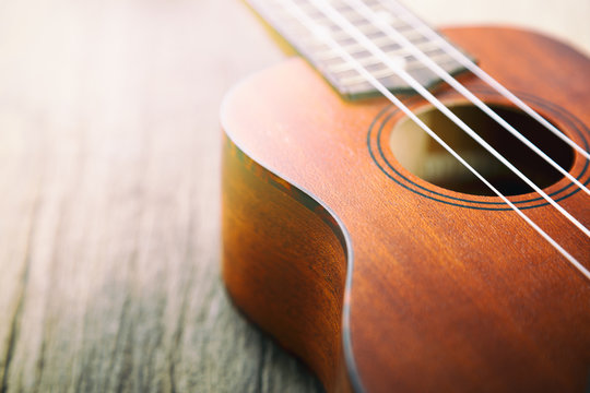 Close up of ukulele on old wood.