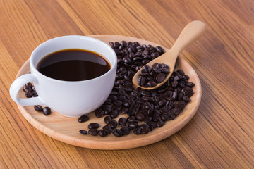 Coffee cup and beans on wooden background