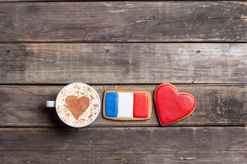 heart and french flag shaped cookies and cup of coffee on the wonderful brown wooden background