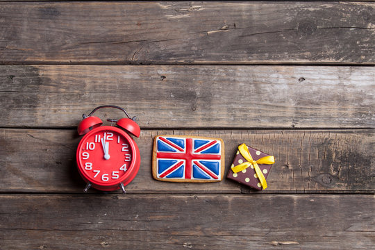 red alarm clock, gift and british flag shaped toy on the wonderful brown wooden background