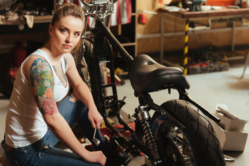 Fototapeta na wymiar Serious young woman while sitting near her bike