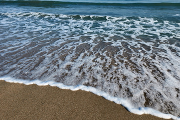 fleeing a foamy wave on the sand beach