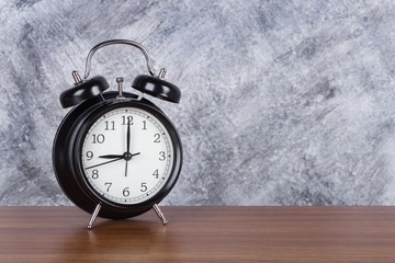 9 o'clock vintage clock on wood table and wall background