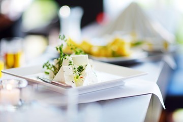 Different kinds of wine snacks and variuos cheeses on white table