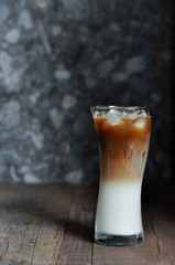 Refreshing iced coffee latte on wooden table in restaurant and cafe