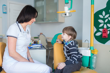 happy female dentist with talking to child
