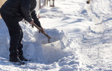 Worker cleans snow shovel