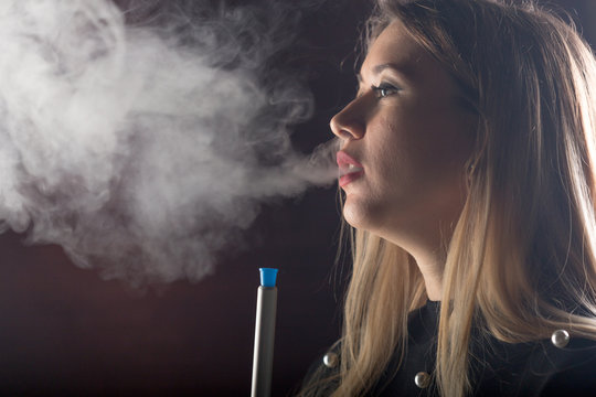 Young, beautiful girl smokes a hookah