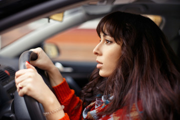 Fototapeta na wymiar Close up of young woman driving a car