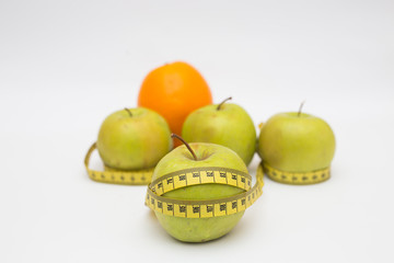 Green apple core and measuring tape orange. Diet concept