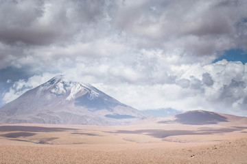 Fototapeta na wymiar Storm over volcano peaks in the dry desert of the high Andes. Volcanoes in the Andes Mountain range, Chile border with Bolivia, South America.