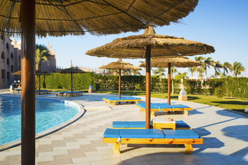 Blue sun chairs on the background of  swimming pool