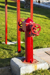 Fototapeta na wymiar Red fire valve on background of green grass