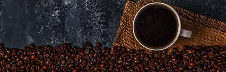 Coffee cup and coffee beans on dark background