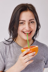 Close Up of a girl drinking a juice from orange fruit