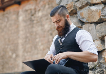 Obraz premium Portrait of a man with the laptop computer outdoors