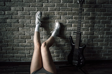Young European teenage brunette  model ,  wearing blue jeans mini shorts, sneakers, and white t-shirt and a cap