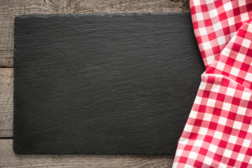 Rustic wooden boards, red checkered napkin and black slate dish with copy space for your menu or recipe. Menu card for restaurants. © svetlana_cherruty